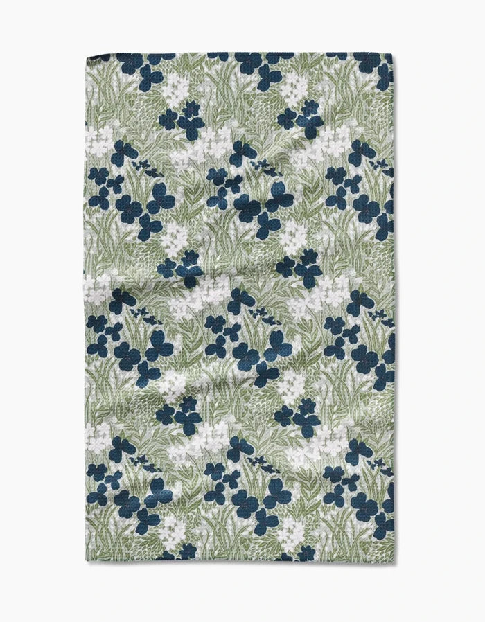 The Navy And Sage Meadow by Katie OShea is a rectangular cloth made from ultra-absorbent Geoweave fabric, featuring a dense pattern of dark blue and white flowers with green leaves and stems on a light background.