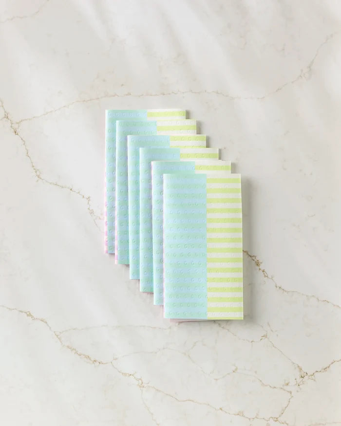 Six vibrant Neon Nights kitchen towels from GEOMETRY, fanned out on a white marble surface—a stylish, eco-friendly alternative to paper towels for sustainable cleaning.