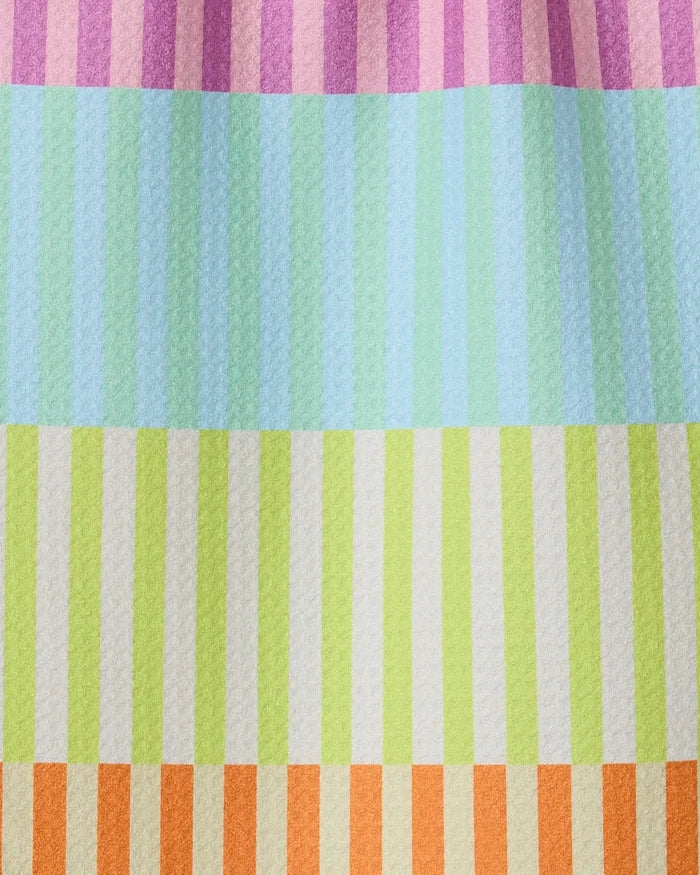 A close-up of the GEOMETRY Neon Nights towel, featuring ultra-absorbent fabric with pastel pink, blue, green, and orange horizontal stripes. Each band has alternating light and dark vertical accents for a modern kitchen style.