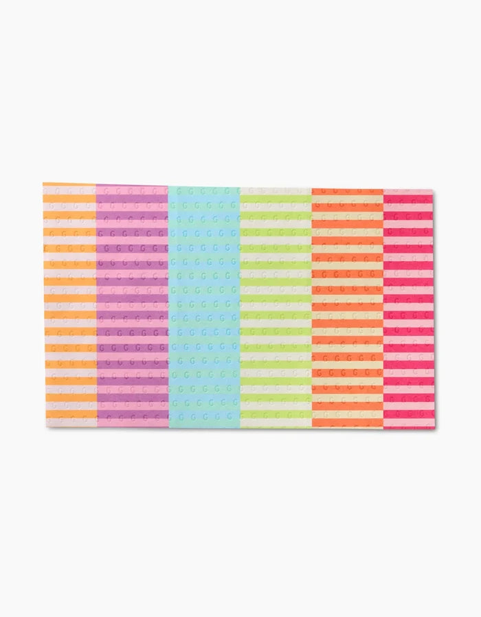 The GEOMETRY Neon Nights features a flat rectangular surface with rows of reusable LEGO bricks in vibrant stripes of orange, purple, blue, green, white, and pink—an eco-friendly alternative to paper towels!.