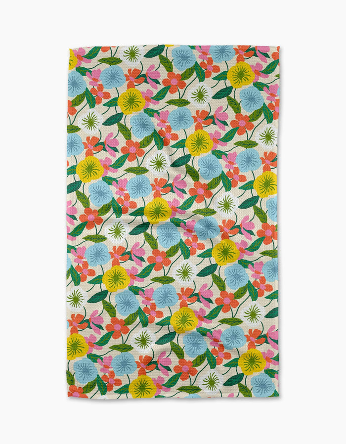The New Mercies tea towel by Susan Heid features a colorful floral pattern with yellow, blue, orange, and pink flowers and green leaves on white, made from quick-drying recycled materials.