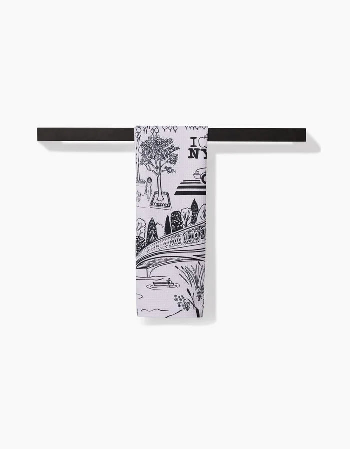 The Elisabeth Wing New York towel, featuring a black and white NYC scene on ultra-absorbent Geoweave fabric, is neatly folded over a simple black bar with a plain white background.