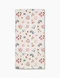 The North Meadow Morning Bar Towel by Charlie Rowan Designs features a colorful pattern of strawberries, cherries, bees, flowers, leaves, and shapes in pink, yellow, green, and purple on white—crafted from sustainable recycled materials.