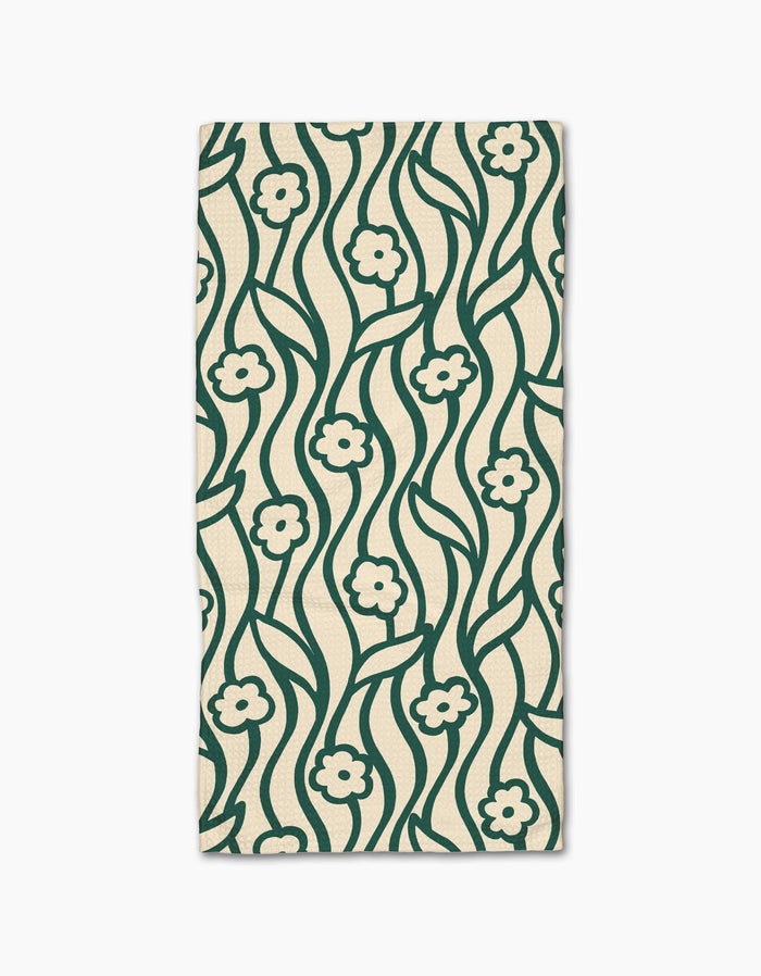 The Nostalgic Flowers kitchen towel by Gerdadzy is a rectangular beige recycled napkin featuring a dark green wavy floral pattern with small flowers and stems, symmetrically repeated across the fabric.