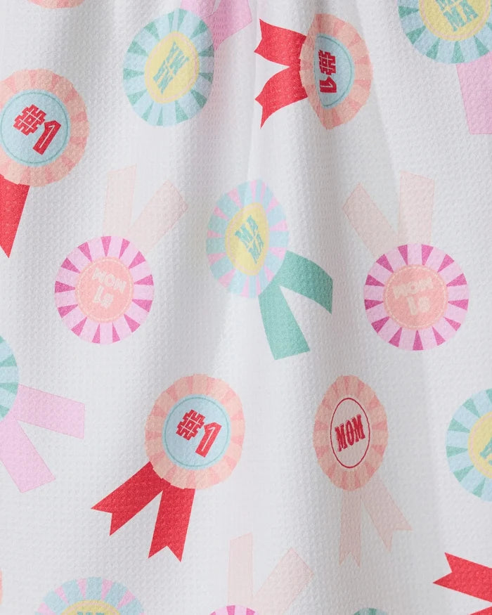 The GEOMETRY Number One Mom towel features colorful rosettes with #1 and MOM text in pink, blue, and yellow on white. Ultra-absorbent and stylish, its perfect for use as a kitchen tea towel.