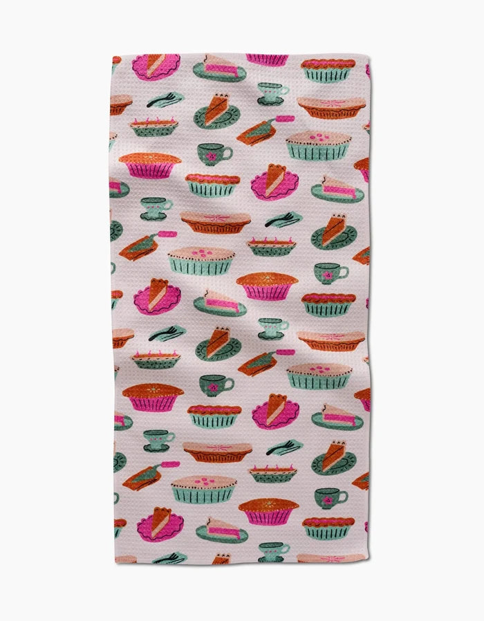 The Amy MacCready Orla Bar Towel showcases colorful illustrated pies, slices, and baking dishes in pink, orange, green, and blue on white Geoweave fabric for absorbency.