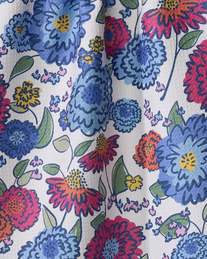 The Painterly Meadow tea towel by Kris Ruff features a close-up of colorful, hand-drawn blue, red, pink, orange, and yellow flowers with green leaves on white. Ultra-absorbent with a slightly textured surface and soft folds.