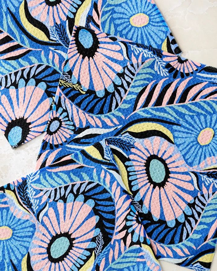 Palm Beach recycled dishcloths by Masha Volnova feature a colorful abstract floral design with bold pink and blue flowers, turquoise centers, and flowing leaves. The vibrant, textured pattern overlaps on each rectangular piece in this lively set.