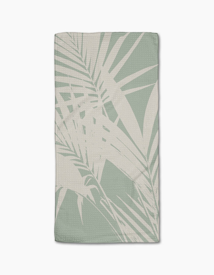The Geometry Palm Breeze Bar Towel is a light sage green towel with textured Geoweave fabric and a beige palm leaf pattern, shown flat on a white background.