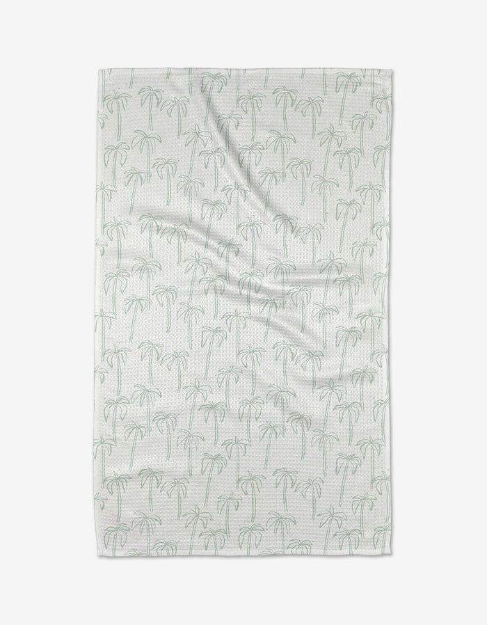 The Palms kitchen towel by Jen B. Peters is white with a subtle pattern of light green palm trees and small dots, shown flat against a white background.