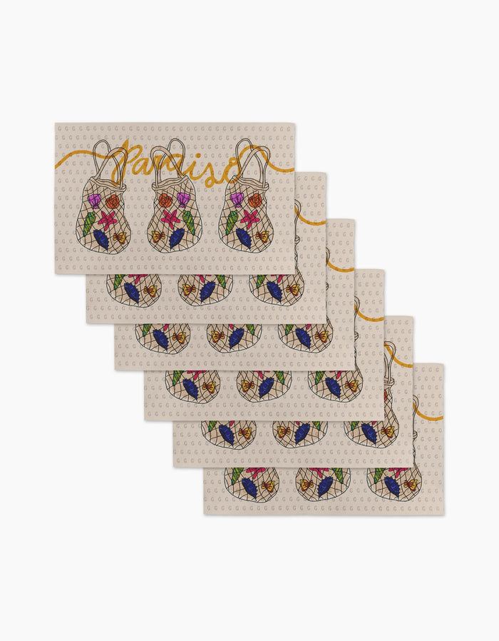 Six reusable rectangular placemats from Geometry’s Paraiso collection feature two baskets of colorful fruit, “paraiso” in yellow script, and a light polka dot background—an eco-friendly alternative to Not Paper Towels.