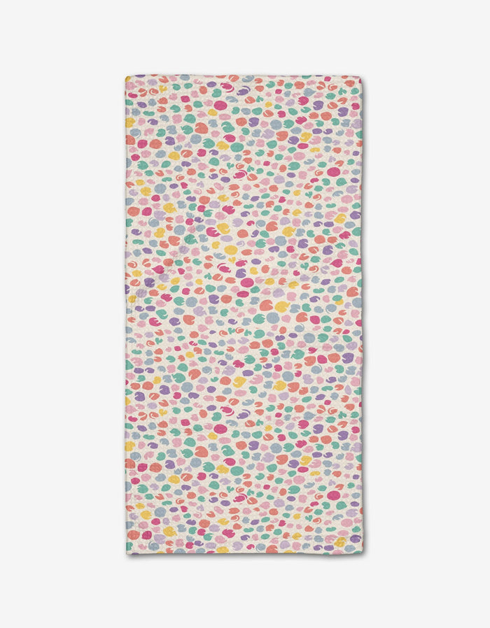 The Pastel Petal bar towel by Rebecca Bobko features pink, yellow, red, green, and purple polka dots on a white background. Made from eco-friendly Geoweave fabric.