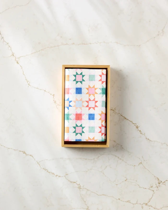 The Patchwork Picnic box by Brittany Jepsen features a colorful geometric star lid and pastel tones, perfect for storing reusable paper towels. Add charm and eco-friendly style to your kitchen with this eye-catching storage solution.