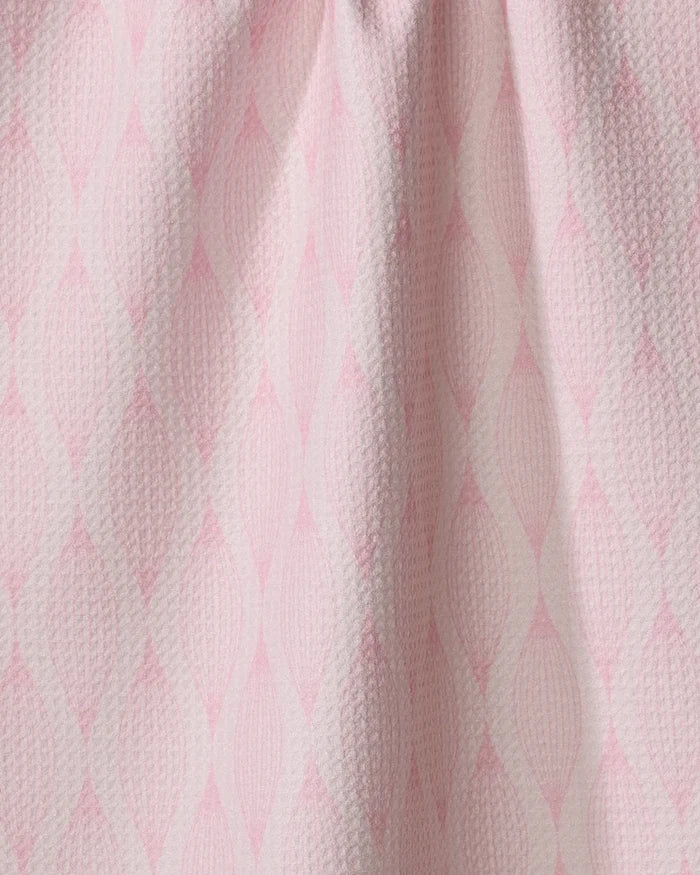 Close-up of Shelley Smith’s “Patterned in Pink” kitchen towel, featuring a repeating diamond pattern in soft pink and white. Made from recycled materials, the fabric is slightly gathered at the top for gentle folds.
