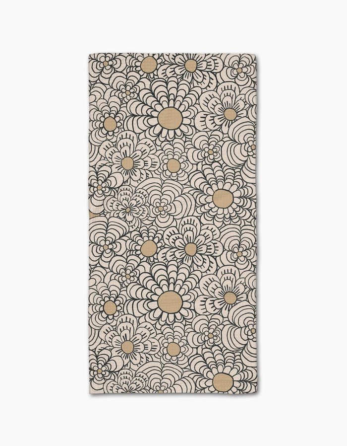 The Paulette bar towel by Amy MacCready showcases a bold black and tan floral pattern with large, stylized flower shapes on ultra-absorbent beige Geoweave fabric covering the entire rectangular surface.