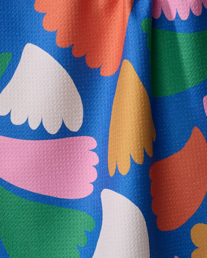 Bring a splash of color to your kitchen with the Peacock Flowers tea towel by Jennifer Bouron—a quick-drying, textured fabric in blue with abstract petal shapes in pink, white, orange, yellow, and green.
