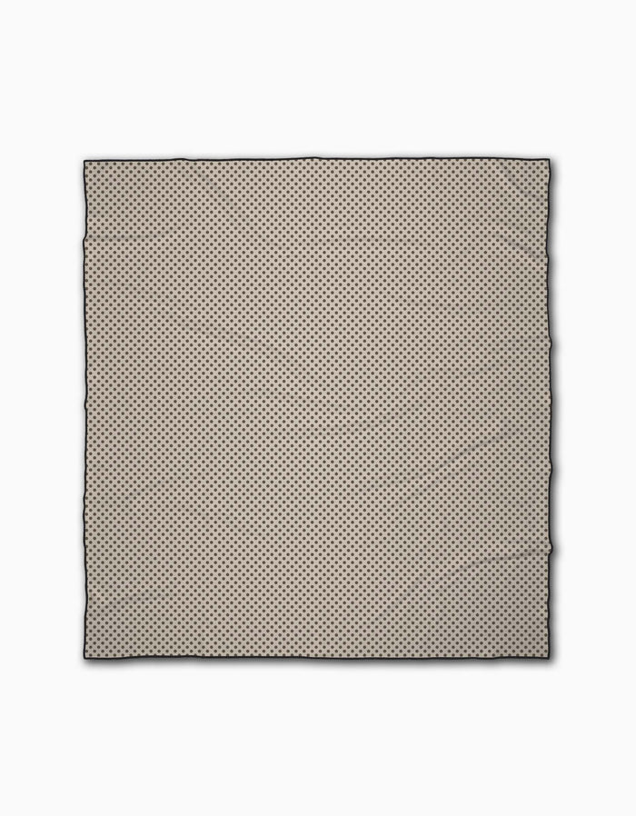 The Pebble by Jenny Keller is a square beige Micro-loop Beach Blanket featuring small, evenly spaced black polka dots and a thin black outline, shown flat against a white background.