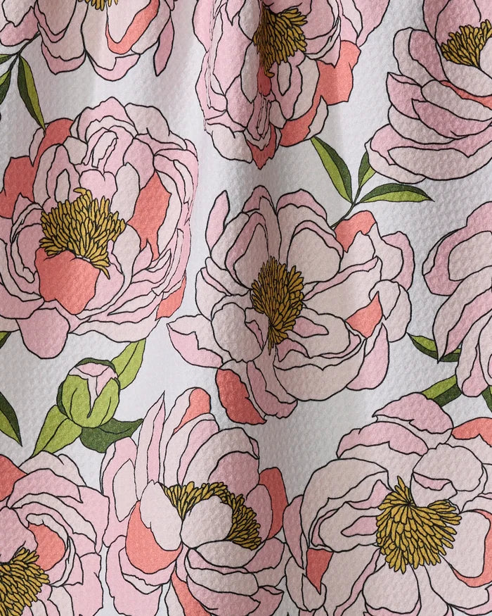 A close-up of Shelley Smith's Peony Paradise dish towel, featuring large pink peonies with yellow centers and green leaves on a textured white fabric—an absorbent and stylish way to brighten your kitchen.