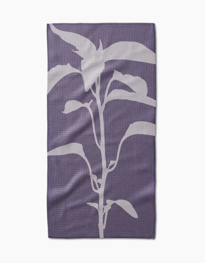 Pepper by PrintedPlant: a purple bar towel crafted from recycled materials, displaying a centered white, stylized plant silhouette with multiple leaves on a plain background.