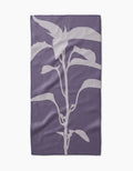 Pepper by PrintedPlant: a purple bar towel crafted from recycled materials, displaying a centered white, stylized plant silhouette with multiple leaves on a plain background.