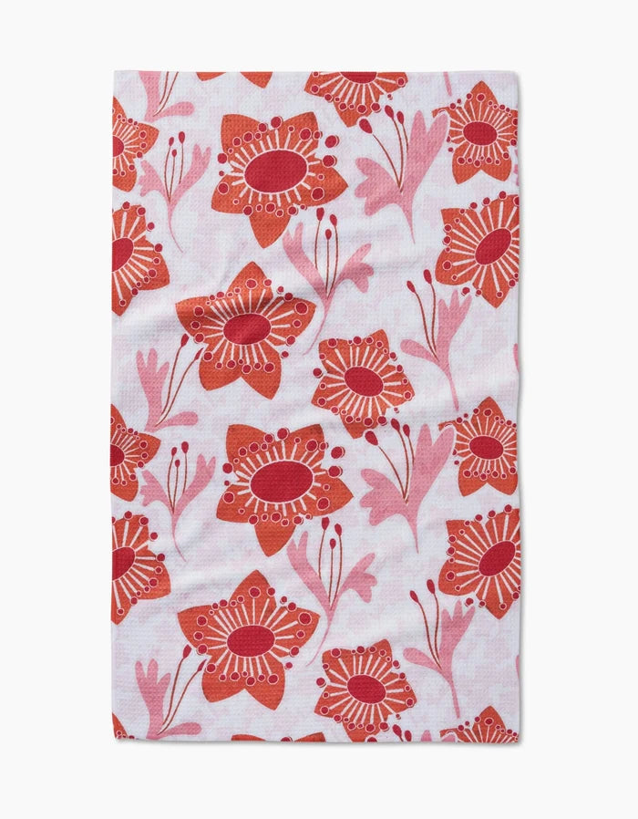 The Petal Paradise tea towel by Whitney Urquhart is made from Geoweave fabric and features red and pink stylized flowers with circular and dotted centers on a white background.