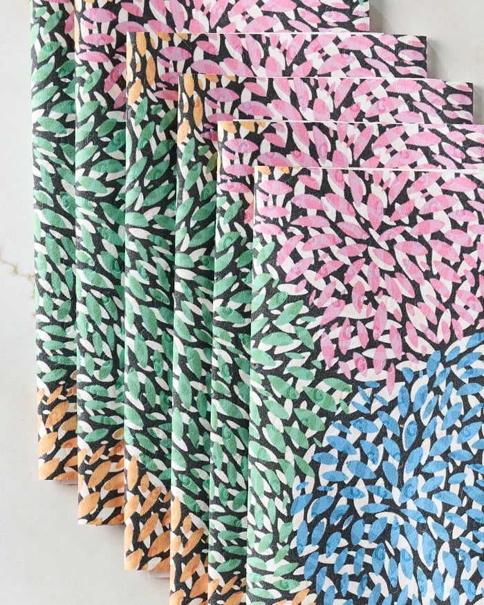 Rachel Parker's Petal Pen features several folded, reusable paper towels in a row, each adorned with a floral pattern of pink, green, orange, and blue petal-like shapes on a white background.