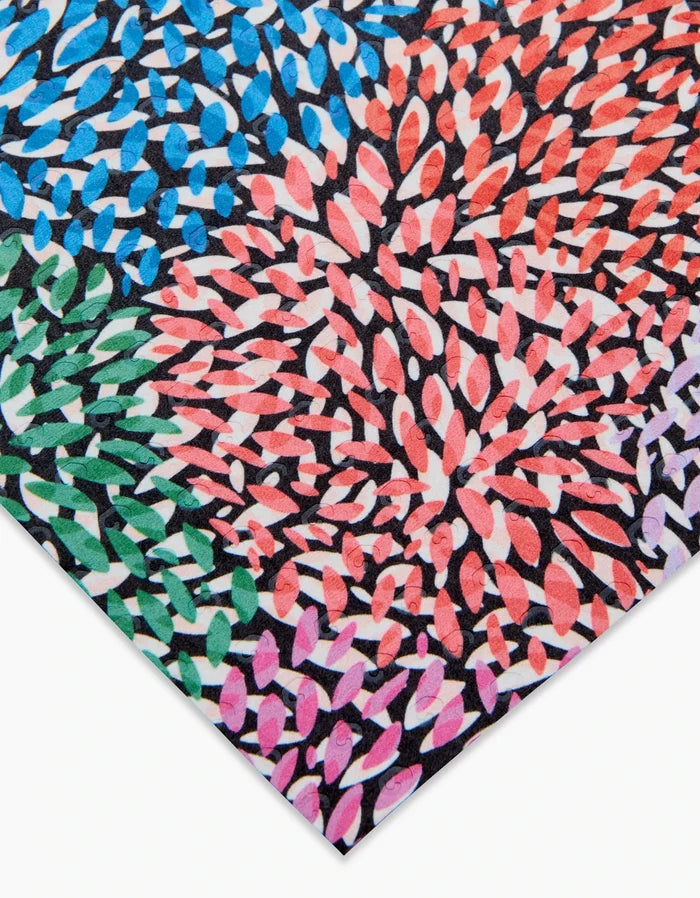 A close-up of Rachel Parkers Petal Pen—colorful abstract artwork with blue, red, pink, green, and black leaf-like shapes swirling on white—evokes a vibrant, eco-friendly spirit.
