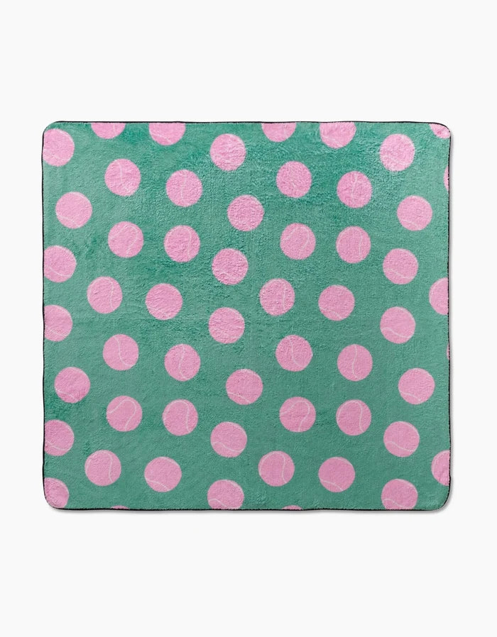 The Pink Ball dog towel from Geometry is a square, ultra-absorbent accessory made from recycled materials. It features evenly spaced pink polka dots on a solid green background for a fun, playful look.