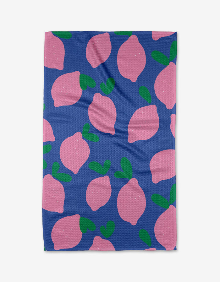 The Pink Lemons blanket by Jennifer Bouron is quick-drying, with a blue background and a scattered pattern of large pink lemons and green leaves.
