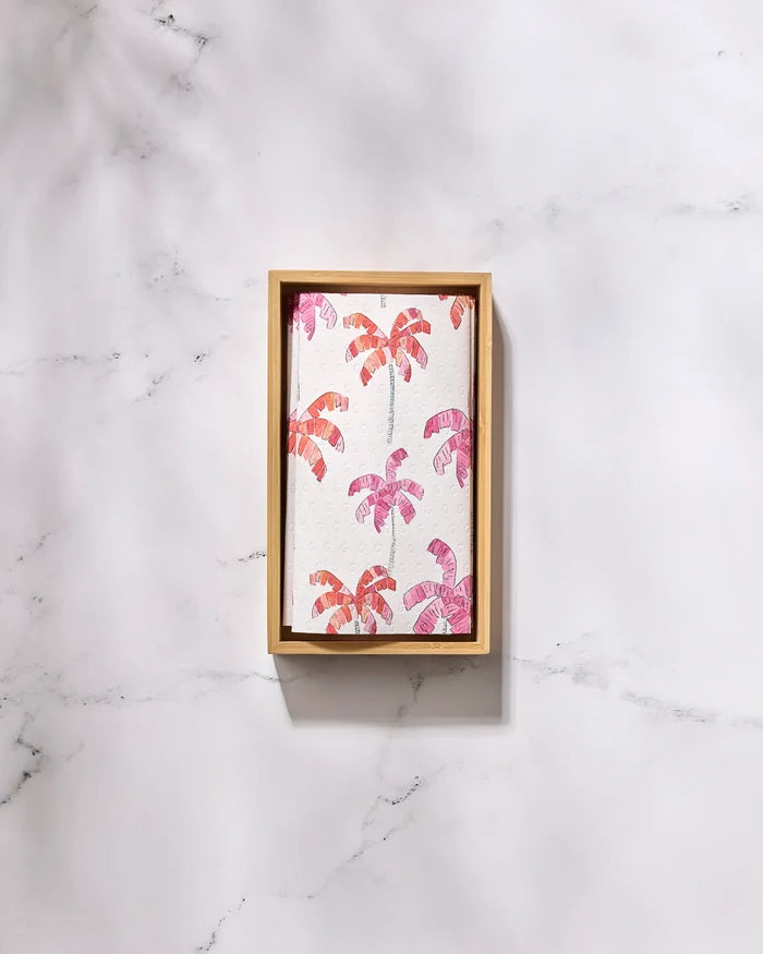 The GEOMETRY Pink Palms tray features a white surface with pink and orange palm trees, making it ideal for serving snacks or displaying reusable paper towels in style.