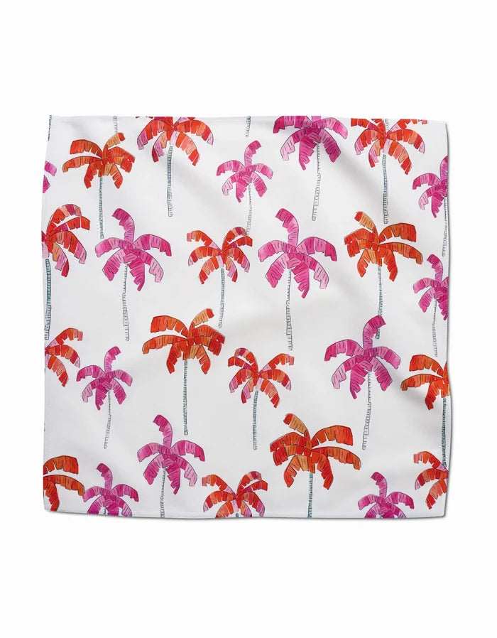 The Pink Palms blanket by GEOMETRY is white, made from recycled materials, and features rows of pink and orange palm trees with slender gray trunks and vibrant fronds.