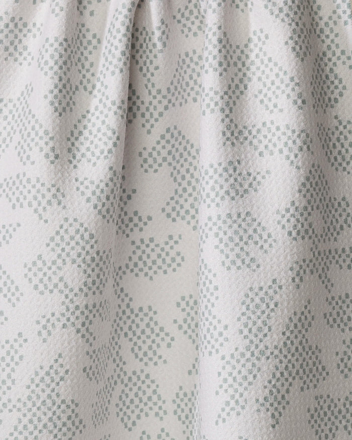 Close-up of the Pixie Sage dish towel by Studio Jeannot in light grey, showcasing a quick-drying fabric with a soft feel. The subtle dotted pattern forms an abstract floral or leaf design, adding gentle texture and charm.