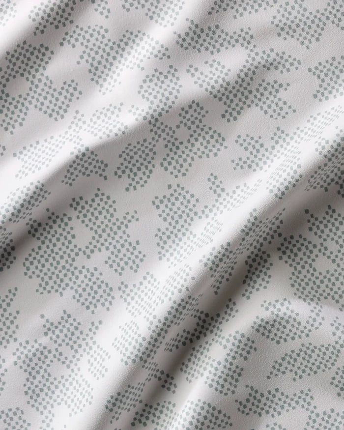 Pixie Sage by Studio Jeannot features white fabric with subtle, light blue-green abstract dot patterns. Its slightly wrinkled texture adds character, making it an elegant and stylish choice for dinner napkin sets.