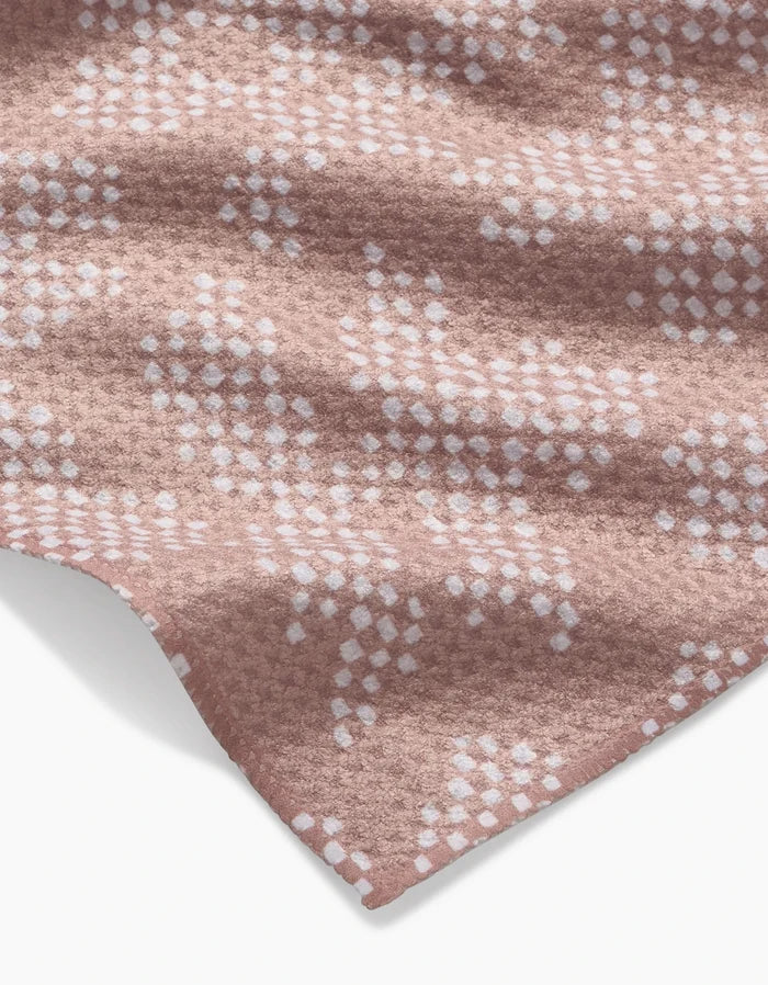 A close-up of Studio Jeannot’s Pixie Geoweave fabric: soft, cozy, and textured with a white geometric dot pattern on a pink background, crafted from recycled materials.