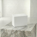 White insert box on a marble surface with a neutral background