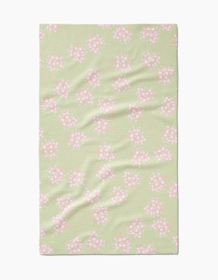 The Pocket of Posies by Sarah Reed is a light green Geoweave towel featuring a textured surface and an ultra-absorbent design, decorated with small pink and white flowers with green stems evenly scattered across it.