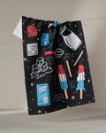 The Popsicles kitchen towel by Janna Sue Design is made from recycled materials and dries quickly. It features colorful milk, ice cubes, popsicles, recipe cards, and utensils on black with red, blue, and white accents.