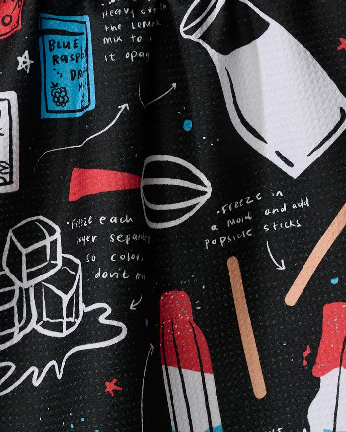The "Popsicles" tea towel by Janna Sue Design features colorful drawings of ice cubes, a bottle, whisk, popsicle sticks, and a blue raspberry drink mix packet with handwritten instructions—made from quick-drying recycled materials.