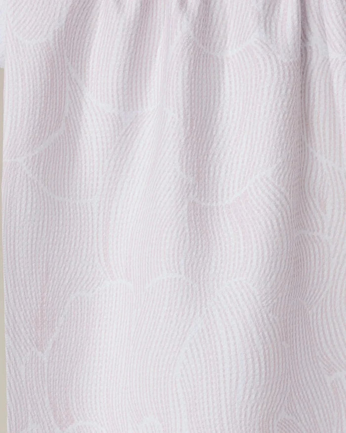 Close-up of the Geometry Posh Petals Blushed Bergamot tea towel, featuring a light pink and white wavy textured pattern with gathered folds, crafted from recycled materials.