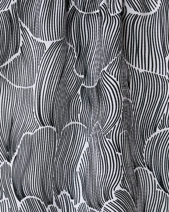 The Geometry Posh Petals Fresh Linen towel features a black and white abstract pattern with curved, vertical lines forming leaf-like shapes, adding movement and texture to this ultra-absorbent and stylish textile.