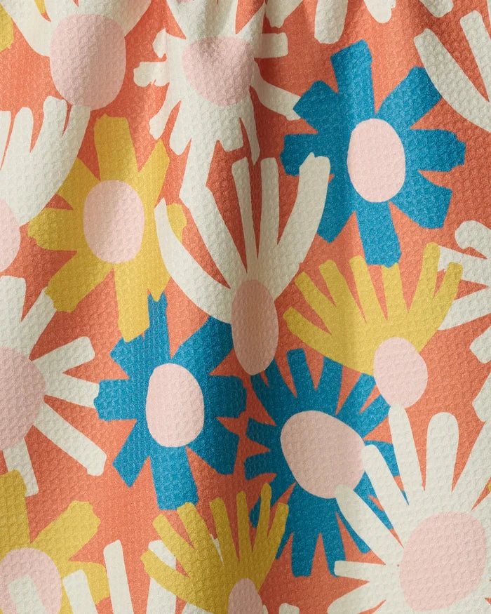 Posy by Kelsey Weigl features abstract daisy-like flowers in blue, yellow, white, and light pink on a textured coral background, creating a vibrant touch for any recycled kitchen towel or absorbent dish towel.