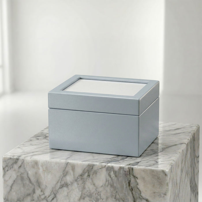 Blue urn box with a clear lid on a marble surface