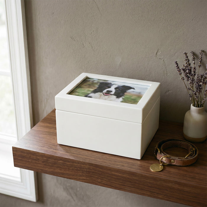 White pet urn with a photo of a dog on a wooden shelf.