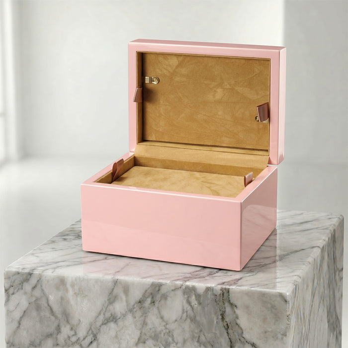 Pink pet urn with open lid on a marble surface