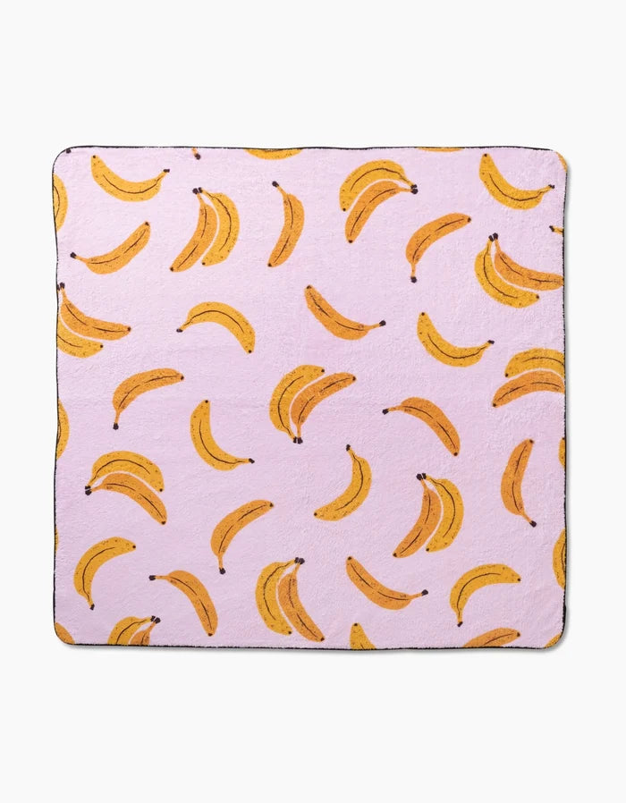 Pupnana by Geometry is a luxurious dog towel crafted from recycled materials, featuring a light pink background with a playful yellow banana pattern.