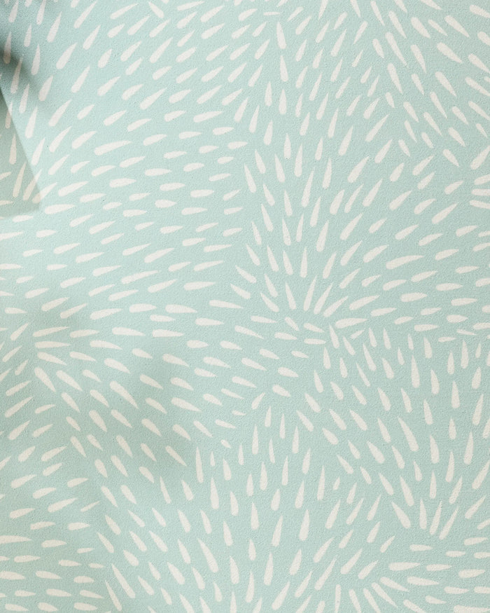 The Quill Blue yoga towel by Rebecca Woolbright features a light blue hue and a starburst pattern of small white ovals, creating movement and texture across its recycled, non-slip surface.
