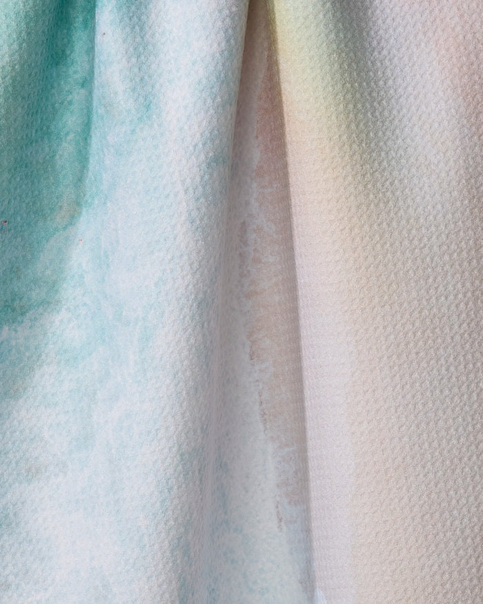 Close-up of the Kait Hanson Rainbow Wave dish towel, featuring a textured, absorbent fabric with soft blue, green, and beige pastel watercolor patterns and gentle gradient transitions.