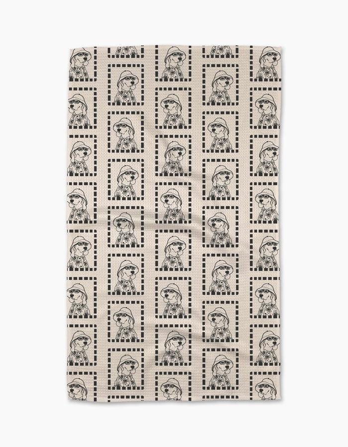 The Geometry Ready For Summer Doggy beige Geoweave™ tea towel features a grid of dotted square borders framing repeated black line drawings of a dog in glasses and a scarf.