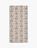 The Geometry Ready For Summer Doggy Bar Towel is rectangular, beige, and features a soft Geoweave fabric with a black line art pattern of a girl in a beret and striped shirt inside checkered squares.