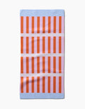 The Red Glow Bar Towel by Happy Hemera features vertical red and pink stripes with light blue bands at the top and bottom, separated by three pink lines. Made from Geoweave fabric, it lies flat on a white background.